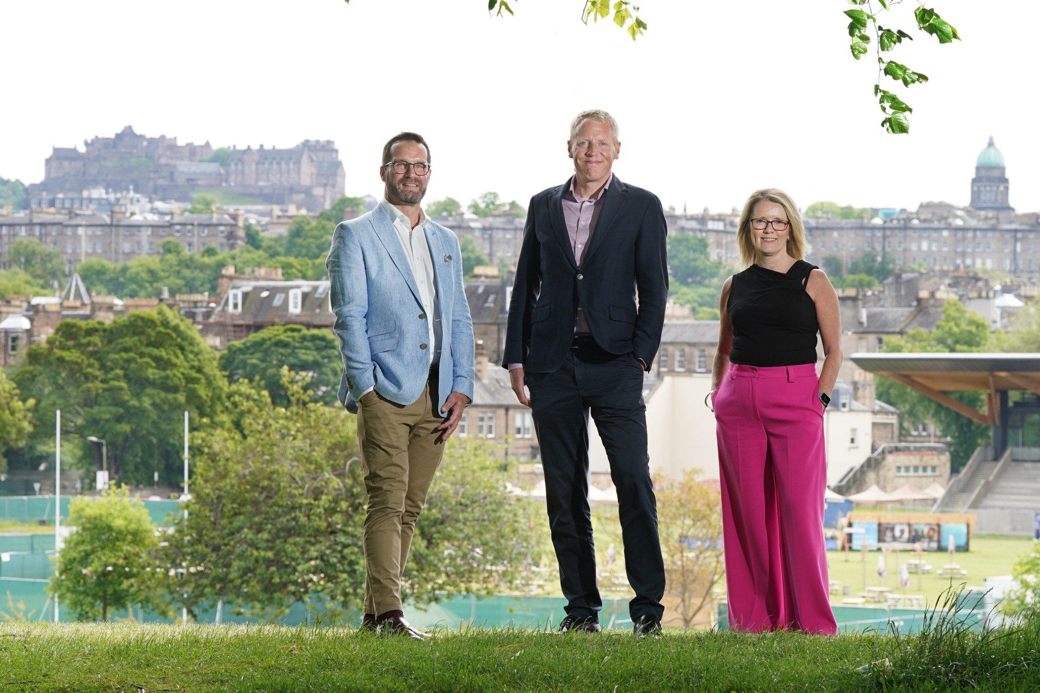 Three people standing in park with Edinburgh Castle in the background