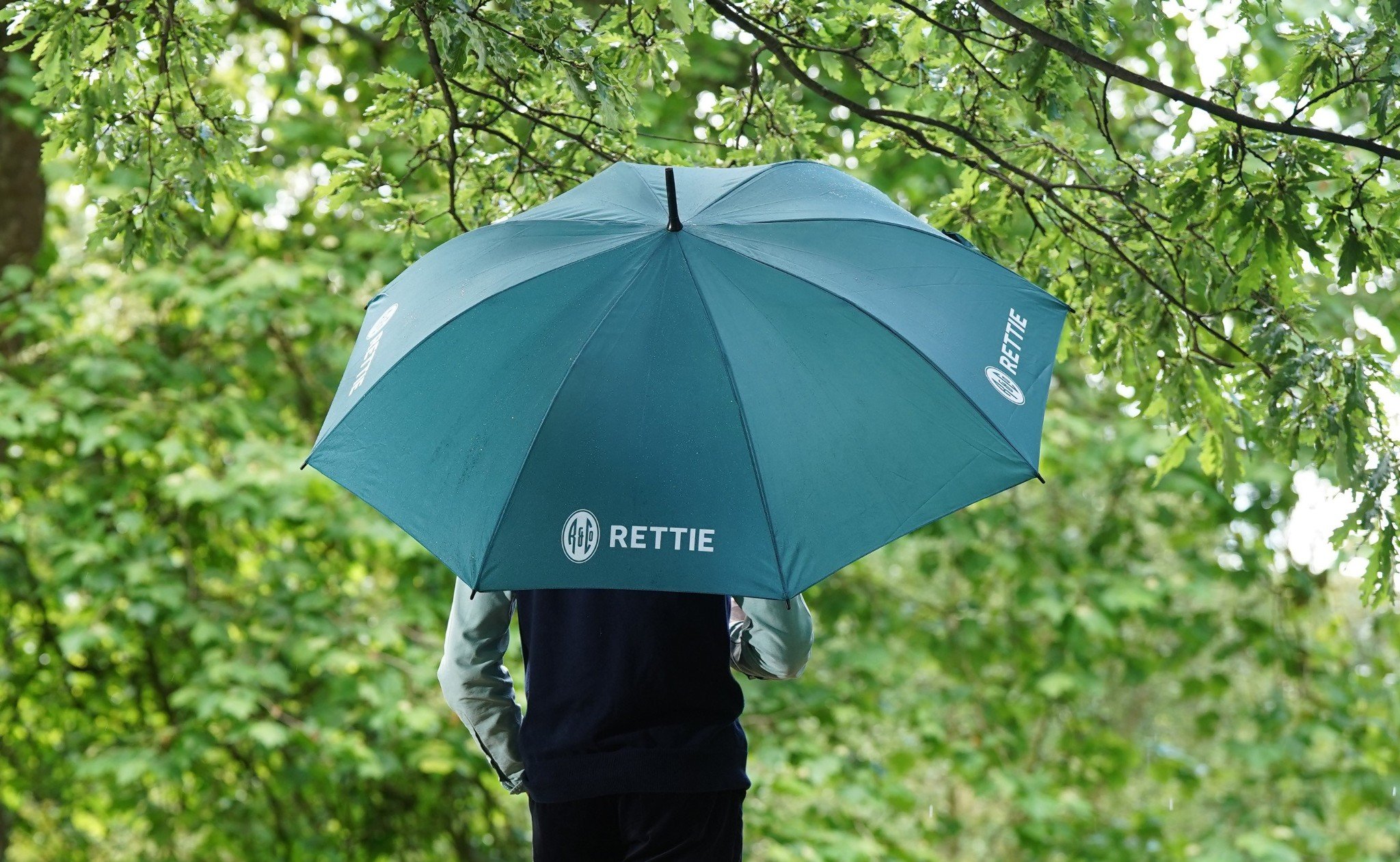 Rettie team member under umbrella