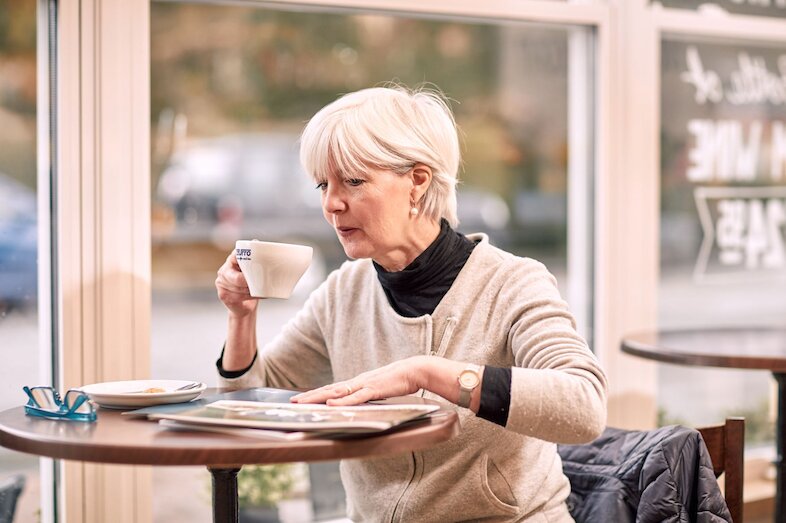 Lady sitting at table drinking coffee