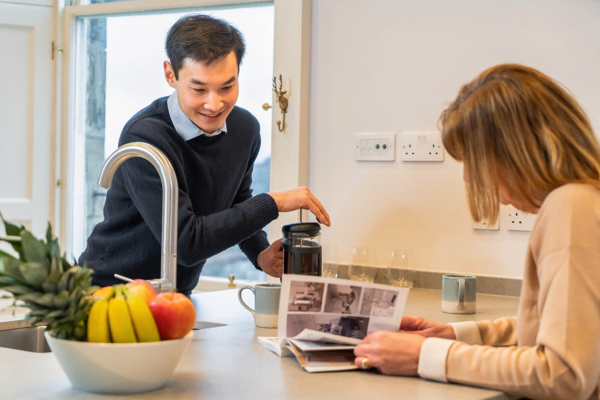 Couple making coffee in kitchen