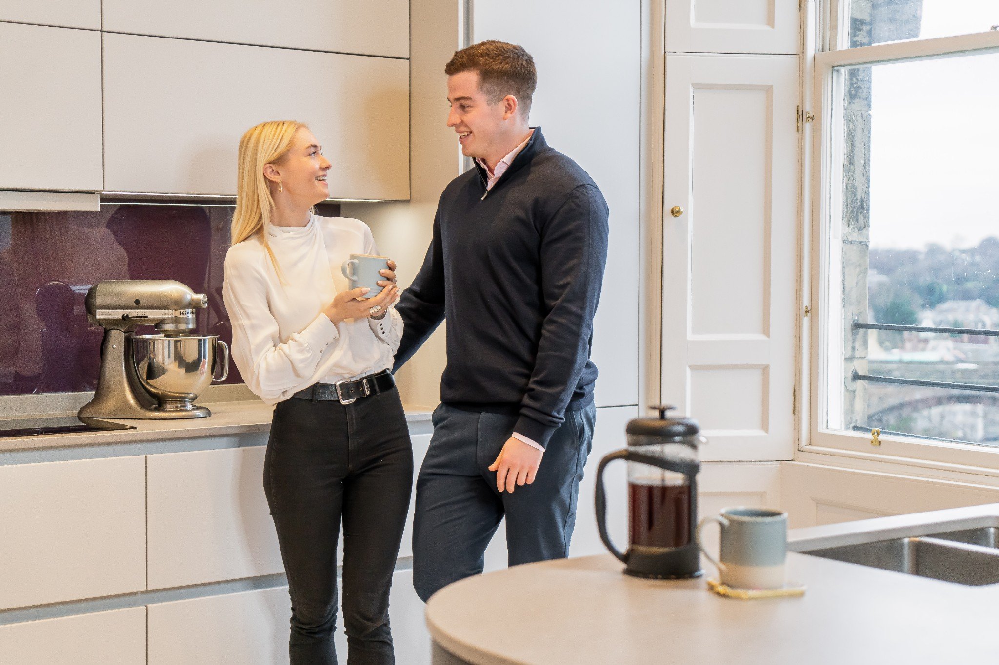 Young couple standing chatting in kitchen